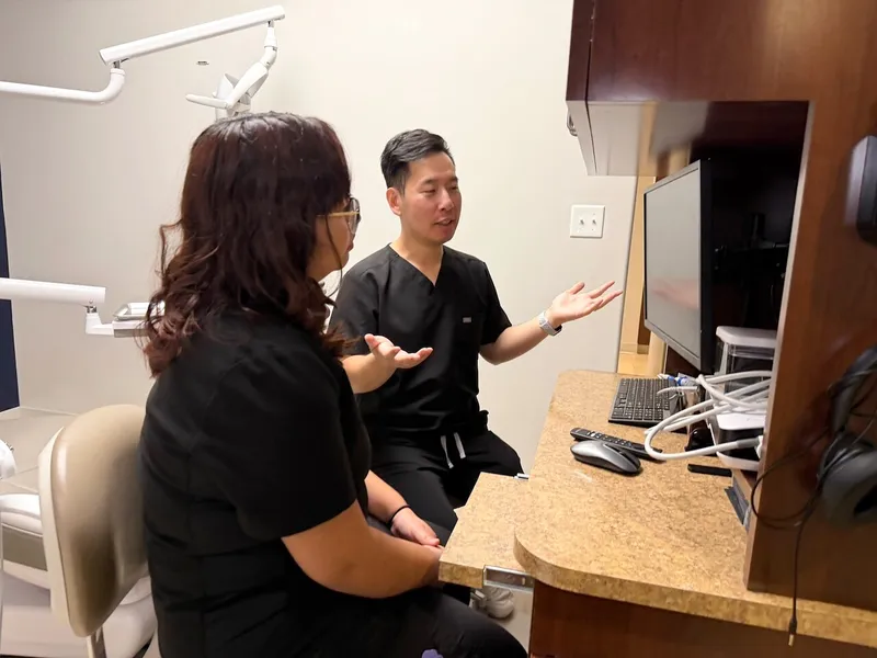 Dr. Tam explains a treatment plan to a patient at the consult desk