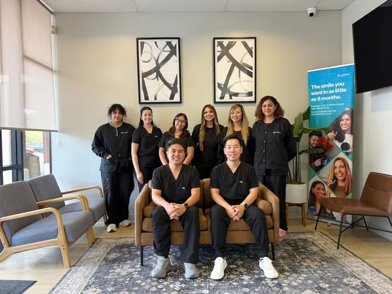 The Custerpoint Family Dental team together in the waiting room, both doctors seated in front
